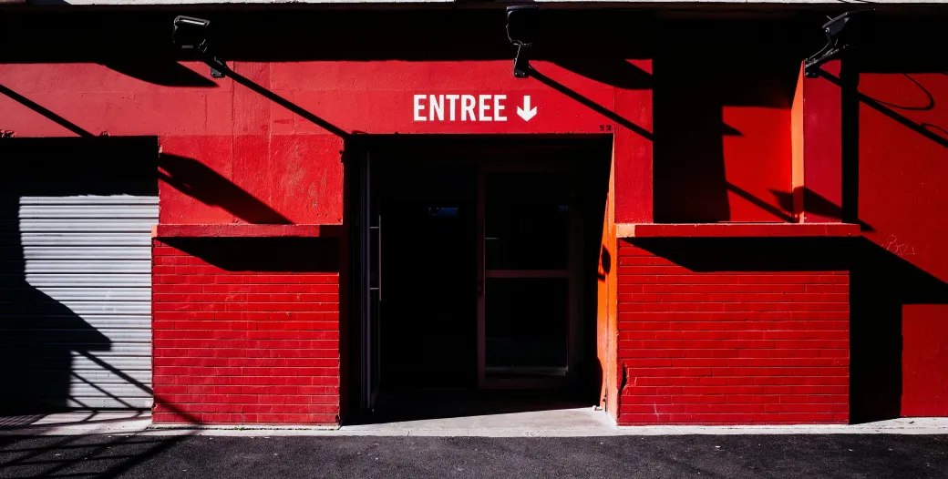 Brick facade painted bright red with a dark entrance at center